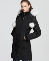 A plush fox fur ruff and playful pom poms lend statement style to this oh-so-warm down parka from Moose Knuckles.