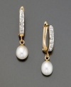 Eternally elegant, these earrings feature cultured freshwater pearls (6 mm) and diamond accents. Set in 14k gold. 1 inch drop.