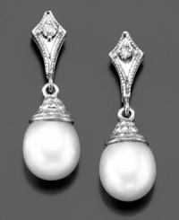 Majestic elegance: cultured freshwater pearl (7-7-1/2 mm) drop earrings with shimmering diamond accents in a 14k white gold setting. Approximate length: 3/4 inch. Majestic elegance: cultured freshwater pearl (7-7-1/2 mm) drop earrings with shimmering diamond accents in a 14k white gold setting. Approximate length: 3/4 inch.