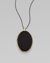 From the Saddle Collection. Sleek and dramatic, a beveled oval of matte black onyx is simply set in a frame of goldplated sterling silver, on a blackened sterling silver chain.Black onyxSterling silver and goldplated sterling silverChain length, about 16-18 (adjustable)Pendant length, about 2Lobster claspImported