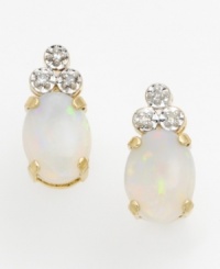 Showing off all the colors of the rainbow, a perfectly oval-cut opal takes center stage in these earrings. Accented with a triangle of round-cut diamonds on top and set in lustrous 14k gold.
