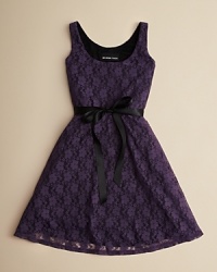 This pretty party dress keeps it simple and elegant with a solid sateen lining and lacy floral overlay, finished with a ribbon bow at the waist. This pretty party dress keeps it simple and elegant with a solid sateen lining and lacy floral overlay, finished with a ribbon bow at the waist.
