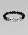 A strand of smooth black onyx beads, capped by dramatic carved raven's heads of sterling silver, clutching the clasp in their beaks. Black onyx Sterling silver Length, about 9¼ Lobster clasp Imported