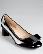 A flirty bow tops the toes of these demure black pumps, finished with grosgain trim. By Salvatore Ferragamo.