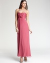 A collection of silk rosettes at the bodice lends romantic appeal to this empire waist gown from Amsale.