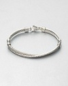 From the Crossover Collection. Iconic cable accented with a ring of pavé diamonds in an intriguing crossover design. Sterling silverDiamonds, .49 tcwDiameter, about 2.5Hinged, lobster clasp closureImported 