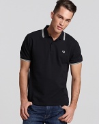 Widely known as the pioneer of Mod, British street fashion, Fred Perry polos have become an iconic fashion silhouette. A sporty polo with contrast double stripe trim and embroidered logo at left chest. Slim fit.