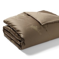 Delicate tree saplings in bronze, gold and umber tones are printed on a twill background on duvets, comforters, and shams in this organic, earthy bedding collection from Calvin Klein Home. Delicate tree saplings in bronze, gold and umber tones are printed on a twill background on duvets, comforters, and shams in this organic, earthy bedding collection from Calvin Klein Home.