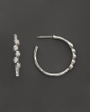 Faceted diamonds gleam in sterling silver hoops. By Ippolita.