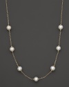 A gold chain necklace with seven freshwater pearl stations.