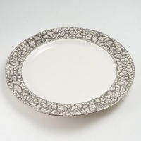 Michael Wainwright has created elegant porcelain since 1991. Each piece is made of porcelain and fired in a kiln at least three times. First, the rims are cut by hand, so that no two pieces are exactly alike. Second, the wares are glazed by hand and fired to nearly 2200 degrees F., 22-karat gold or platinum is hand painted on each piece and fired in a kiln one more time, resulting in a finish that is dishwasher-safe.