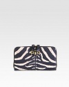 Luxurious zebra-print leather with radiant hardware and secured zipper pulls.Two-way zip-around closureSecured zipper pullsOne inside zip pocketTwo open compartmentsTwelve credit card slotsTwo bill compartmentsFully lined7½W X 4¼H X 1DMade in Italy