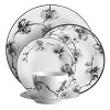 A captivating motif of lifelike orchids stands out in dramatic relief against a backdrop of vibrant white porcelain, giving this dinnerware from Michael Aram bold, artful presence.