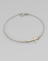 A simple, sleek cross of 14k gold sits sideways within a delicate sterling silver chain in this eloquent design.14k yellow gold and sterling silverLength, about 7Spring ring claspMade in USA