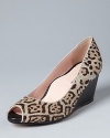 A standout snow leopard print defines these work-or-play open toe wedge pumps. Designer (and orthopedic surgeon) Taryn Rose lends them her signature, won't-want-to-take-them-off comfort.