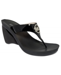 Smooth and shiny. MICHAEL by Michael Kors' Warren wedge sandals mold comfortably to your foot and feature a glimmering brand logo on top of the shiny patent straps. Smooth and shiny. MICHAEL by Michael Kors' Warren wedge sandals mold comfortably to your foot and feature a glimmering brand logo on top of the shiny patent straps.
