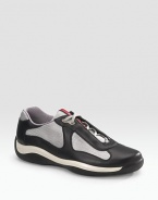 Lace-up sneaker with leather and mesh upper on a rubber sole. Padded insole Molded rubber bottom Imported 