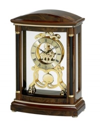 A regal finishing touch for the mantel. This solid wood clock by Bulova is finished in dark wine and features an ornate gold tone dial and gears covered by a glass lens. A regal finishing touch for the mantel. This solid wood clock by Bulova is finished in dark wine and features an ornate gold tone dial and gears covered by a glass lens.