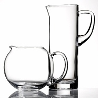 Simple, fluid glass forms with thick shams and hand cut polished edges. A sleek collection of pitchers for entertaining or everyday use. Lead free. Handwashing recommended. Shown from left to right: clear round pitcher, tall glass pitcher. Also available but not shown: Tula curved pitcher. Simple, fluid glass forms with thick shams and hand cut polished edges. A sleek collection of pitchers for entertaining or everyday use. Lead free. Handwashing recommended. Shown from left to right: clear round pitcher, tall glass pitcher. Also available but not shown: Tula curved pitcher.