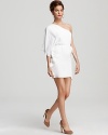 Make your move in all white with this Kimberly Taylor one-shoulder dress, flaunting a short flutter sleeve for elegant detail. Cinched at the waist for feminine shape, this standout look defines high style amongst a sea of LBDs.