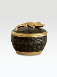 A candle with the intoxicating scent of pink champagne is encased in this vessel with the texture of crocodile skin, handcrafted of fine black Limoges porcelain with 14k goldplated accents. Includes fitted lid with a clasp sculpted in the shape of an crocodile. Handcrafted porcelain 6H X 4 diam. Imported 