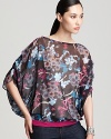 A lush, multi-colored floral print sweeps across this wispy chiffon Sweet Pea blouse for an unmistakably feminine flair.