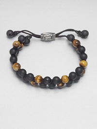 Smooth beaded bracelet of black onyx and tiger's eye with sterling silver lobster clasp.Black onyx/tigers eyeLobster claspAbout 2½ diam.Made in the United Kingdom