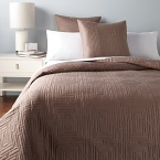 With its clean lines and geometric pattern, this decorative pillow adds richness and depth to the bed.