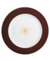 A rich burgundy rim frames a single gold starburst in the center of this striking service plate from Bernardaud.