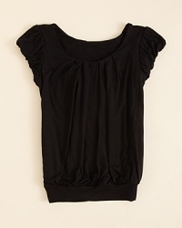 A cap sleeves shirt is embellished with elastic gathers at the shoulder and a wide banded hemline. A cap sleeves shirt is embellished with elastic gathers at the shoulder and a wide banded hemline.