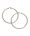 Snap up effortless style in simple hoops. GUESS earrings feature a polished, large hoop design in gold tone mixed metal. Approximate diameter: 1-1/2 inches.