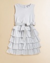 A party-perfect, sleeveless frock is frilly and fun with a ruffled metallic skirt and sash tie waistband.Round necklineSleevelessBack zipperWaistband with sash tieRuffled skirtBodice: CottonSkirt: 52% metallic polyester/48% nylonDry cleanImported