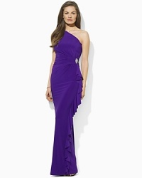 Graceful and elegant in a floor-skimming one-shoulder silhouette, this Lauren by Ralph Lauren gown in slinky matte jersey is accented with gentle ruching, cascading ruffles and a crystal-encrusted brooch for a romantic flourish.