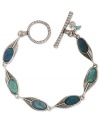 Flaunt what you've got. Lucky Brand's peacock-inspired bracelet combines semi-precious reconstituted calcite turquoise with feather charms. Set in silver tone mixed metal. Approximate length: 7-3/4 inches.