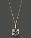 Diamonds frame a green amethyst, set in 14K white gold.