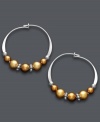 A tri-color blend spices up a traditional pair of hoop earrings. Jody Coyote's unique design offers a metallic mix of copper and gold Austrian crystal pearls threaded onto delicate, sterling silver hoops. Approximate diameter: 3/4 inch.
