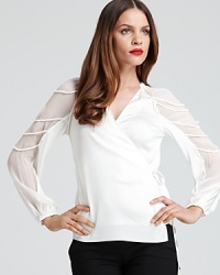 Indulge in a fashion fantasy with this Elie Tahari blouse, finished with sheer sleeves and braided embellishment for an effortlessly romantic style. Indulge in a fashion fantasy with this Elie Tahari blouse, finished with sheer sleeves and braided embellishment for an effortlessly romantic style.
