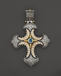 An ornate cross pendant with diamonds and blue topaz in sterling silver with 18K yellow gold accents. From Konstantino.