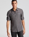 Give your look some edge with this hip button-down from John Varvatos Star USA, featuring double zip chest pockets underneath a pair of besom pockets for unique flair.