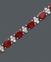 A tennis bracelet to die for. Bold oval-cut garnet (17 ct. t.w.) and diamond-accented links add instant drama. Bracelet crafted in sterling silver. Approximate length: 7 inches.
