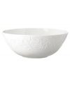 An elegant white-on-white pattern featuring an embossed vine motif and interior glaze lends the Opal Innocence Carved serving bowl to refined dining every day.