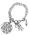Signature style from GUESS. This charming bracelet showcases silver tone pendant -- a large cut-out logo circle embellished with glass stone accents and four number charms showing 1981. Set in imitation rhodium-plated mixed metal with a lobster claw clasp. Approximate length: 7-1/2 inches. Approximate drop: 1-1/2 inches.
