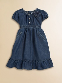 An adorable denim day dress accented with a darling floral detail and silvertone snaps.Jewel necklineCap sleeves with elasticized cuffsFront snap placketConcealed back zip closureElasticized waistbandSide slash zip pocketsRuffle hem65% cotton/35% polyesterMachine washImported An adorable denim day dress accented with a darling floral detail and silvertone snaps.Jewel necklineCap sleeves with elasticized cuffsFront snap placketConcealed back zip closureElasticized waistbandSide slash zip pocketsRuffle hem65% cotton/35% polyesterMachine washImported