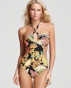 Tropical bound style setters will love this daring cut out monokini from Trina Turk. In a bold print, this suit lends drama to a vacation staples -- a solid tunic and flat sandals.