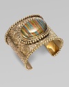 From the Trujillo Collection. An intricately carved, bead-edged cuff, dramatic on its own, has a striated plaque of rainbow calsilica, encased in rock crystal, as its brilliant centerpiece.Rainbow calsilica and rock crystalBronzeDiameter, about 2¼Made in USA