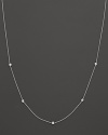 A white gold chain with five bezel-set diamond stations.