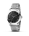 A stainless steel watch from the Gucci G-Timeless collection. Round black dial with pattern and stick hour indices. Sweep second hand and date window.