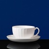 Simple shapes of crisp white are accented with precisely etched lines. Contrasting black matte jasper accessories with glazed interiors are also available. Bone china.