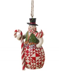 Carrying a candy cane staff to match his scarf, this crafty snowman plays it cool with elaborate carved and quilt-patterned detail in the signature folk-art style of Jim Shore. Carrying a candy cane staff to match his scarf, this crafty snowman plays it cool with elaborate carved and quilt-patterned detail in the signature folk-art style of Jim Shore.