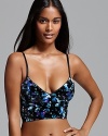 In crushed velvet with a bright floral print, Free People's cropped bustier is a modern take on '80s glam. Style #F355F151.